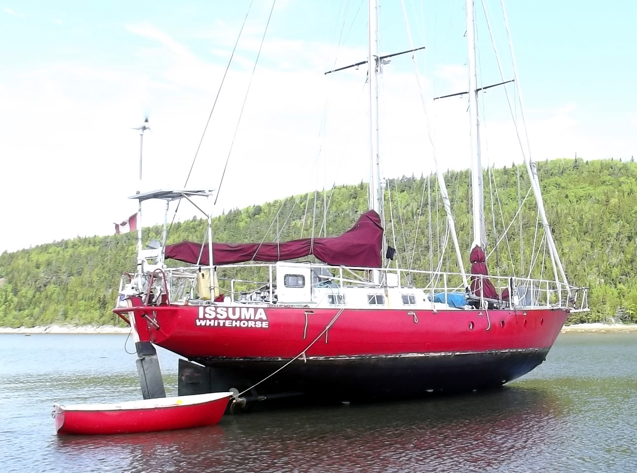 View from starboard quarter of Issuma dried out on beach, showing hull shape